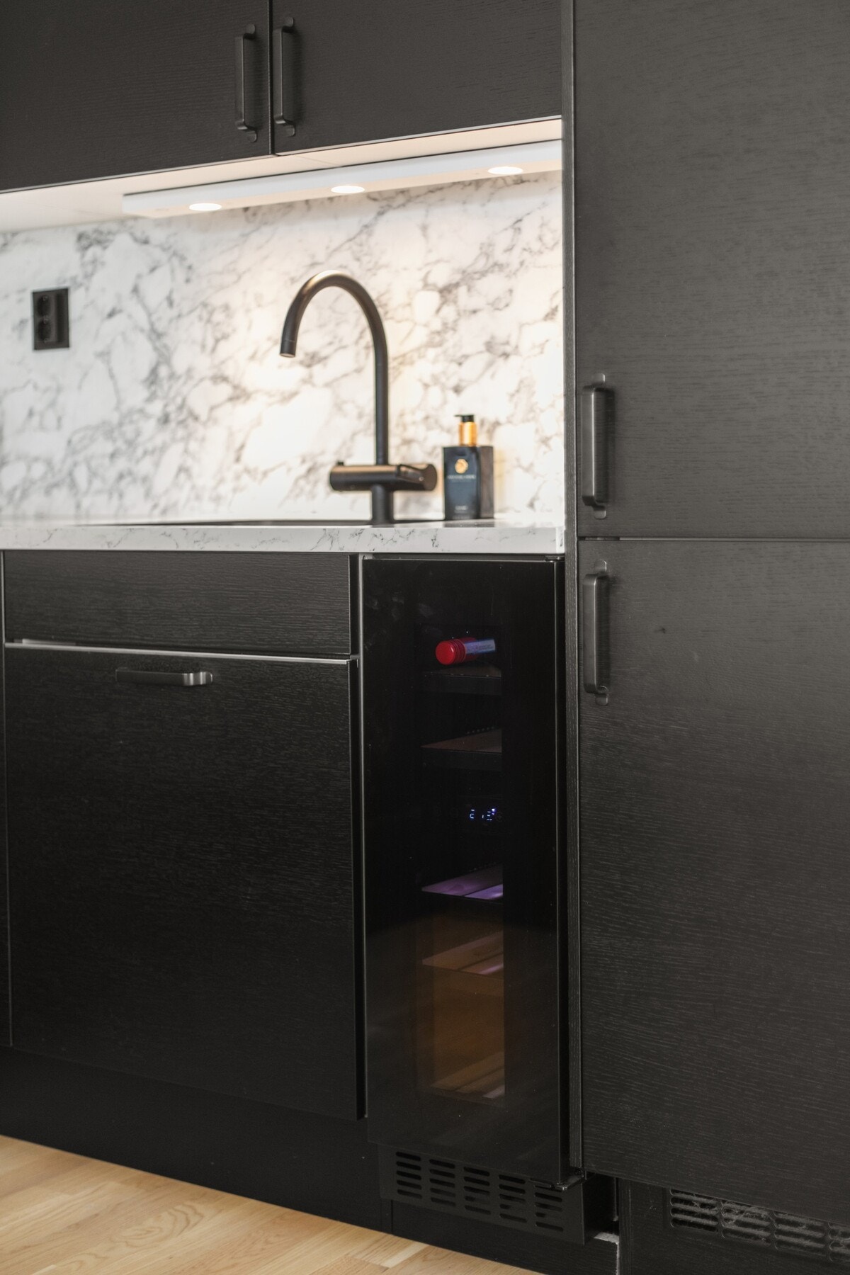 Praktiske laminatplater mellom benk og overskap forenkler rengjøring. Vinskap medfølger. Galleribilde