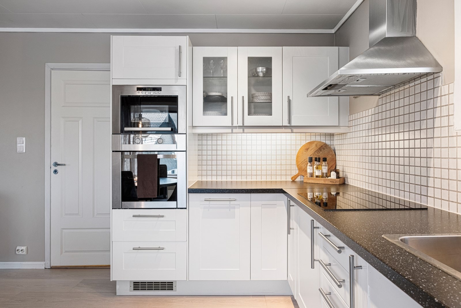 Det er mosaikkflis på vegg over laminat benkeplate. Galleribilde