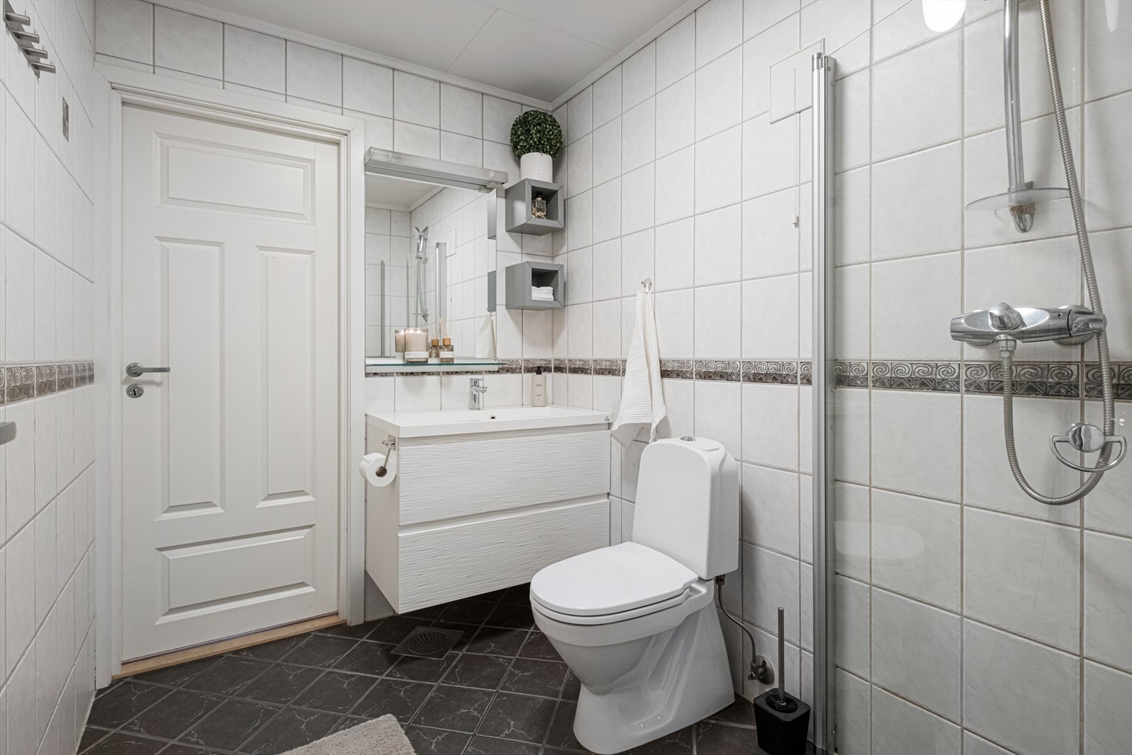 Badet er utstyrt med servantinnredning, servant, dusjhjørne og wc. Galleribilde