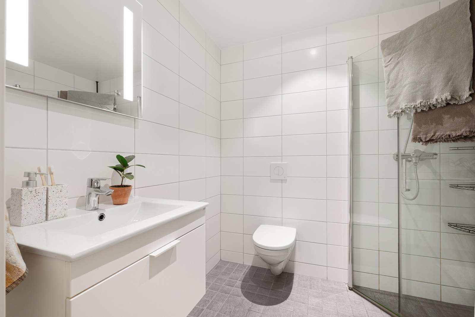 Her får du bl.a veggmontert WC, servant med underskap, speil og 2stk dusjdører i glass. Galleribilde