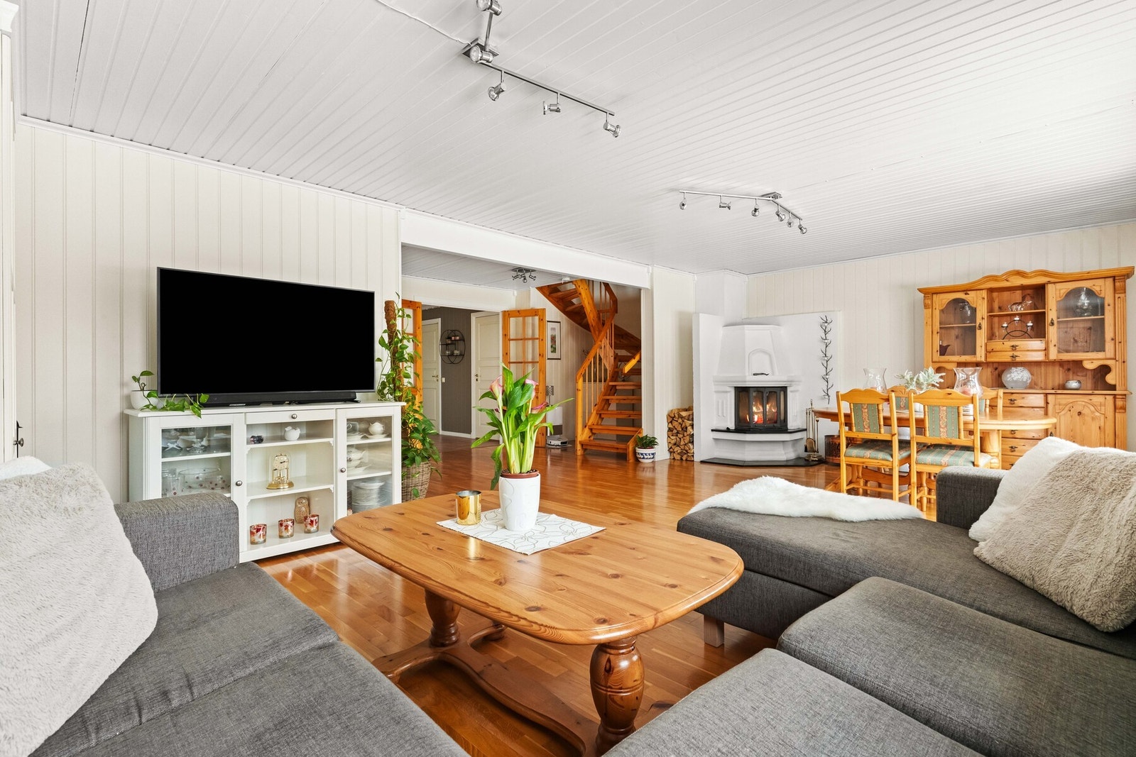 Rommet binder sonene naturlig sammen, der peisen danner et stemningsfullt midtpunkt og gir en ekstra dimensjon til oppholdsarealet. Galleribilde