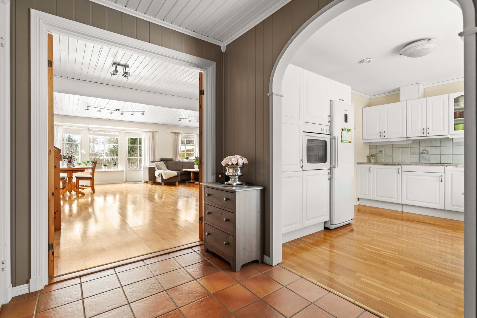 Fra mellomgangen åpner boligen seg på en innbydende måte mot både kjøkken og stue, med buede åpninger som gir særpreg og en mykere romfølelse. Galleribilde