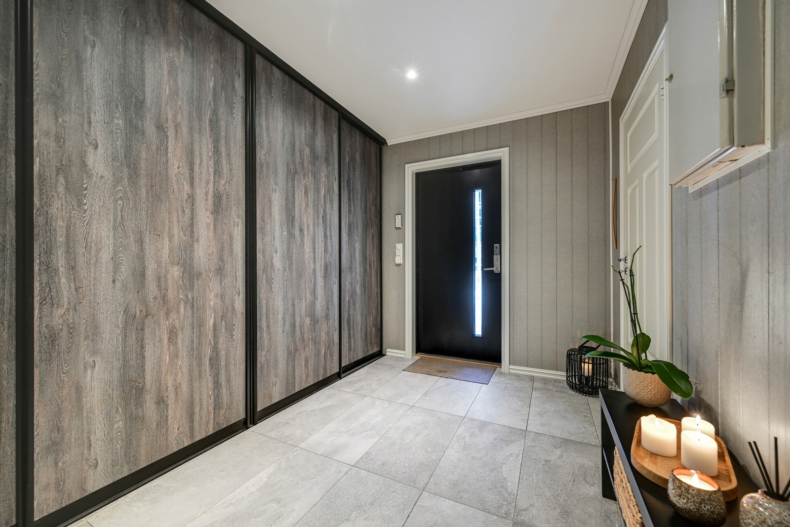 Stor og flislagt entre med fliser/gulvvarme og skyvedørsgarderobe Galleribilde