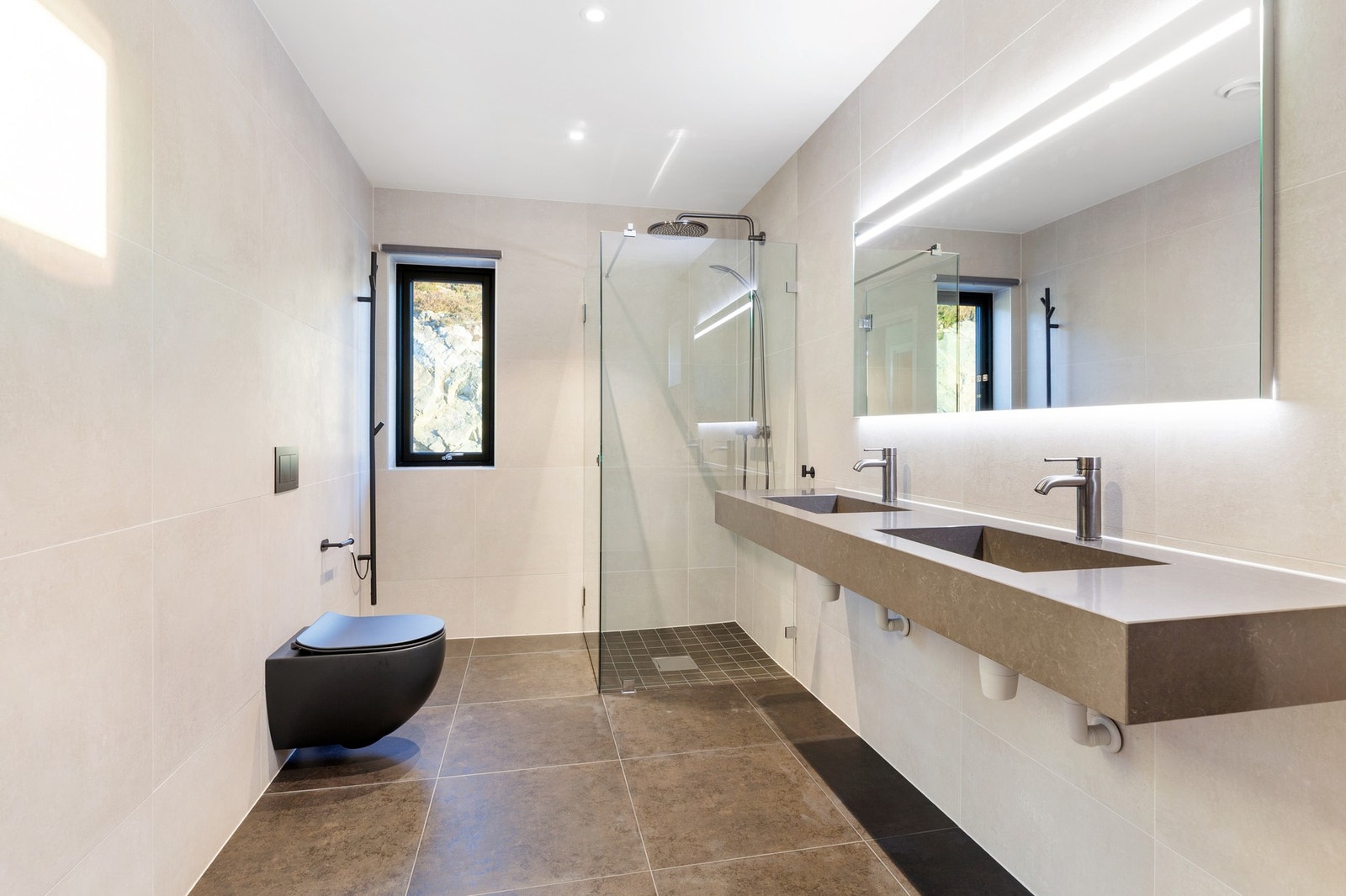 Hovedbad på 10 kvm med adkomst fra soverom. Rommet innehar vegghengt toalett, dobbel servant på vegg og dusjdører med dusjgarnityr på vegg. Galleribilde