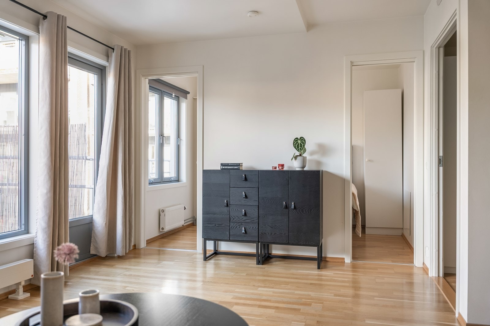 Leiligheten har et lyst soverom, med adkomst fra stuen og hvitmalte vegger. Galleribilde