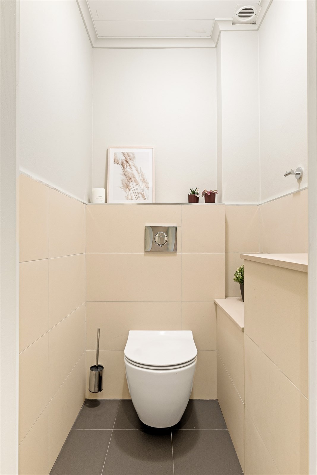 I tillegg finnes et separat toalettrom med fliser på gulv, fliser og malte plater på vegger samt veggmontert wc. Galleribilde