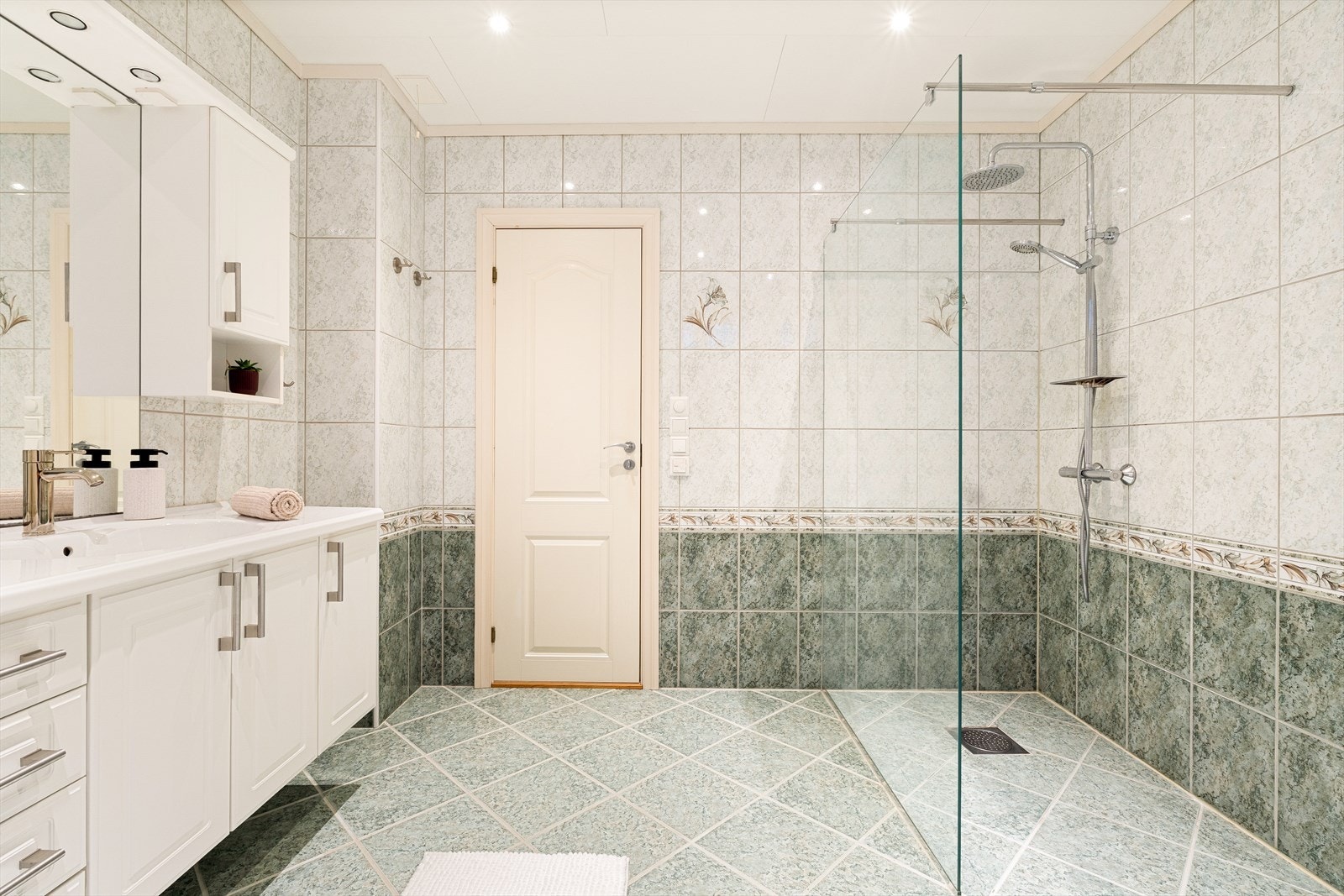 Rommet er innredet med dusjvegg, servant med møblement og wc, og det er opplegg for badekar. Galleribilde