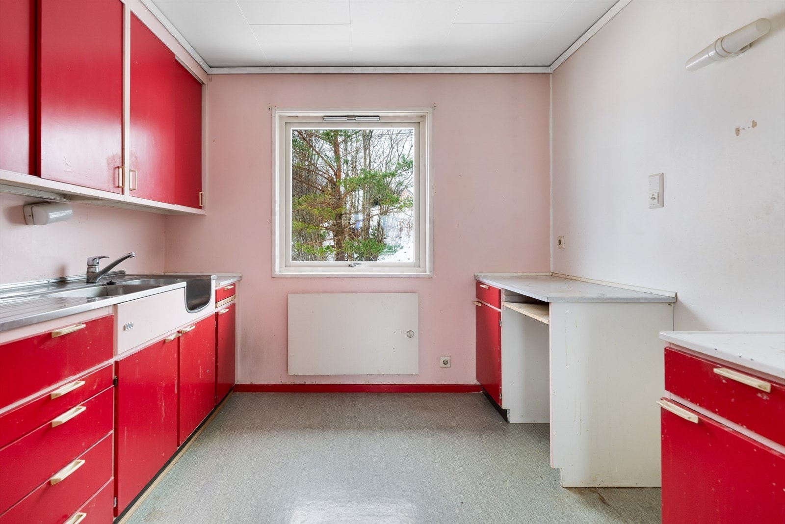 Kjøkken har innredning med slette fronter, laminert benkeplate og stålbenk med vask. Galleribilde