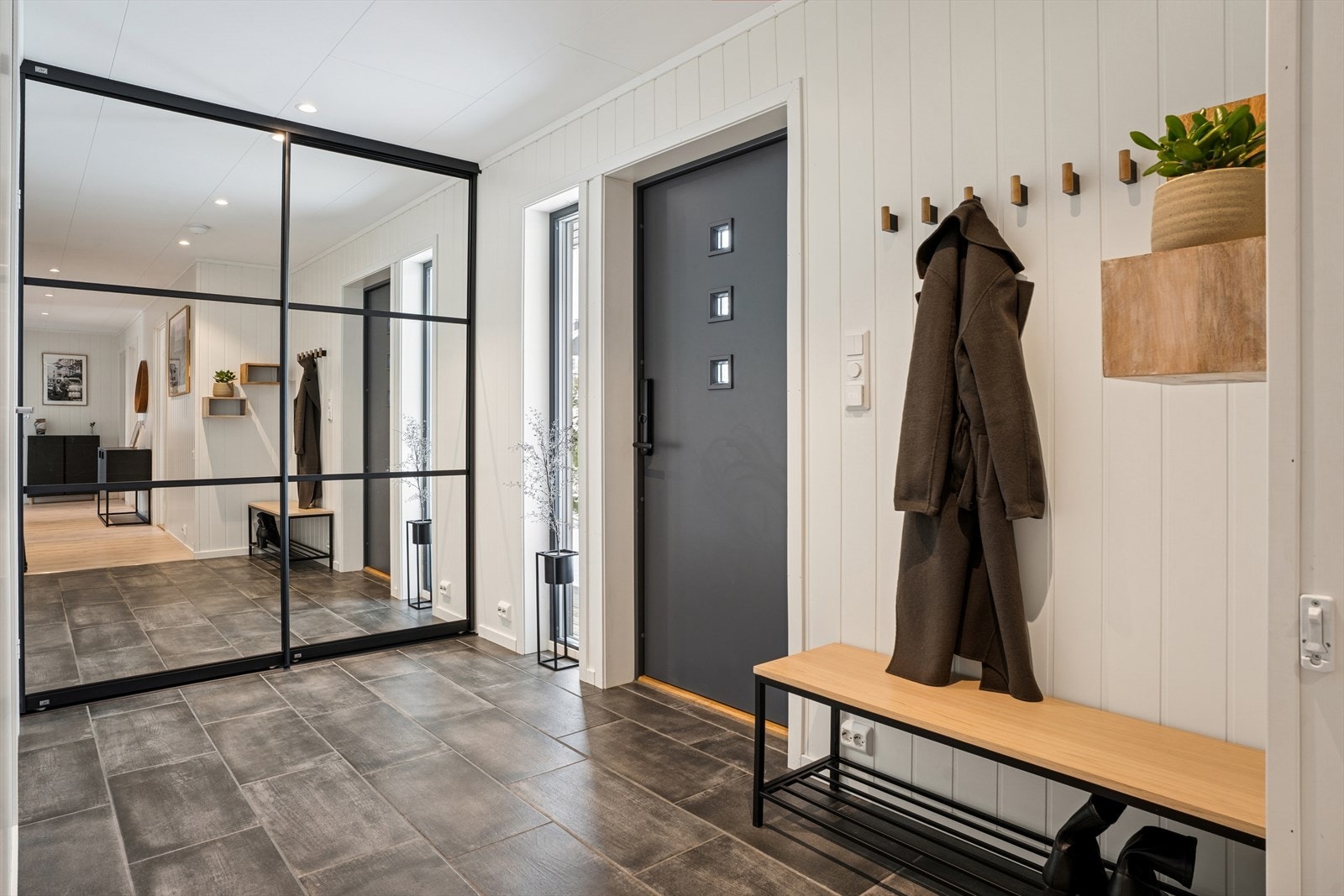 Entré er av god størrelse med plass til yttertøy og sko. Det er god oppbevaringsplass i stor skyvedørsgarderobe, samt varmekabler i gulvet som er praktisk for vått fottøy Galleribilde