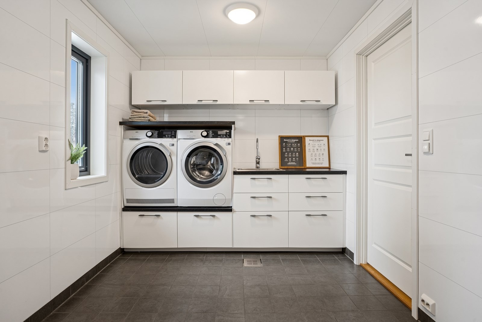 Stort og praktisk vaskerom med meget fin innredning som har plass til både vaskemaskin og tørketrommel Galleribilde