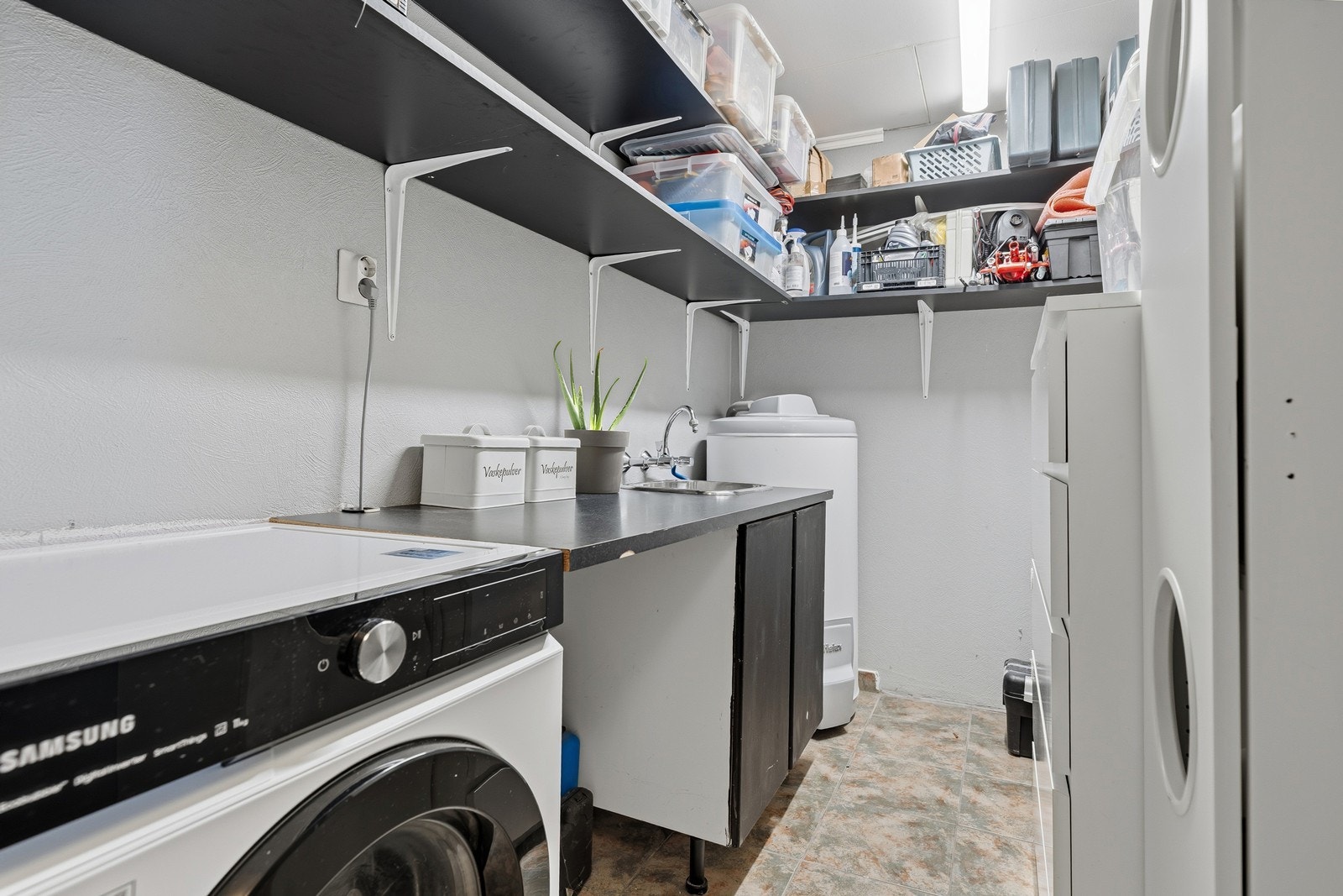 Praktisk vaskerom med hyller og enkel innredning Galleribilde