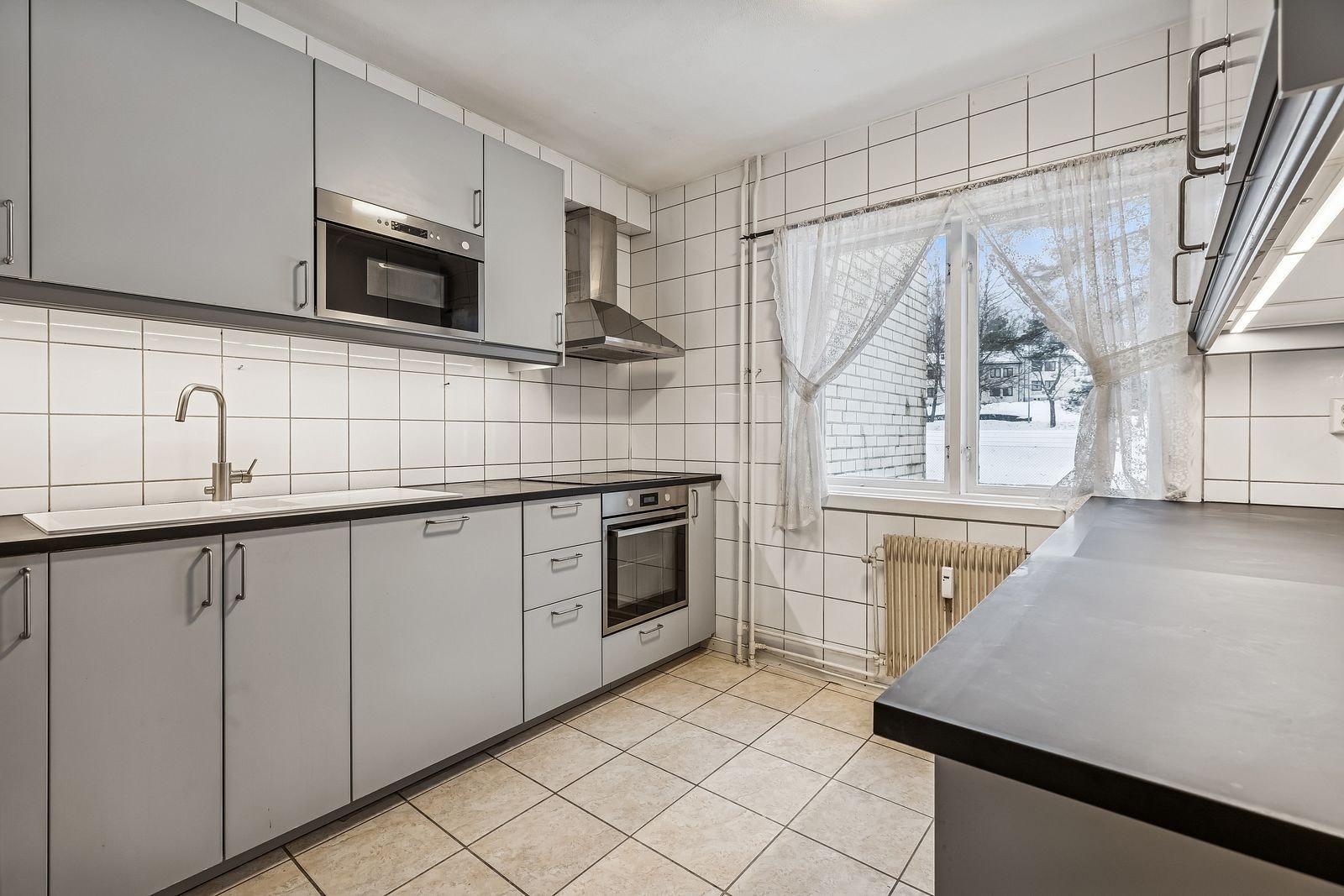 Funksjonelt kjøkken med god skapplass og integrerte hvitevarer. Galleribilde