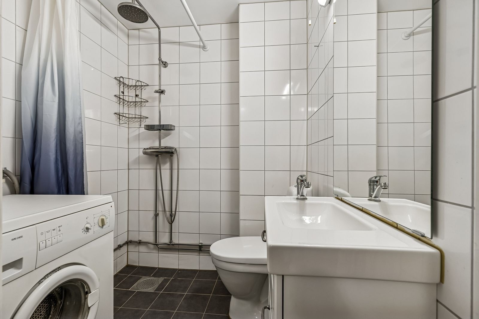 Praktisk bad med dusj, toalett og opplegg for vaskemaskin. Galleribilde