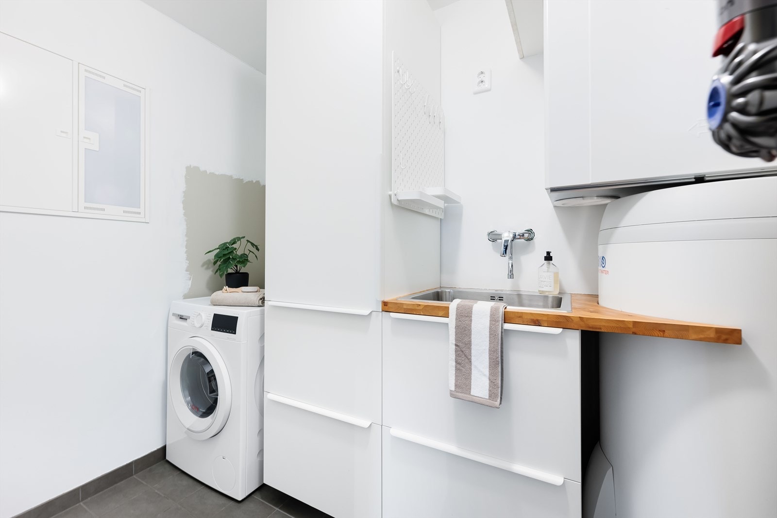 Innredet vaskerom/teknisk rom med flislagt gulv og malte vegger. Galleribilde