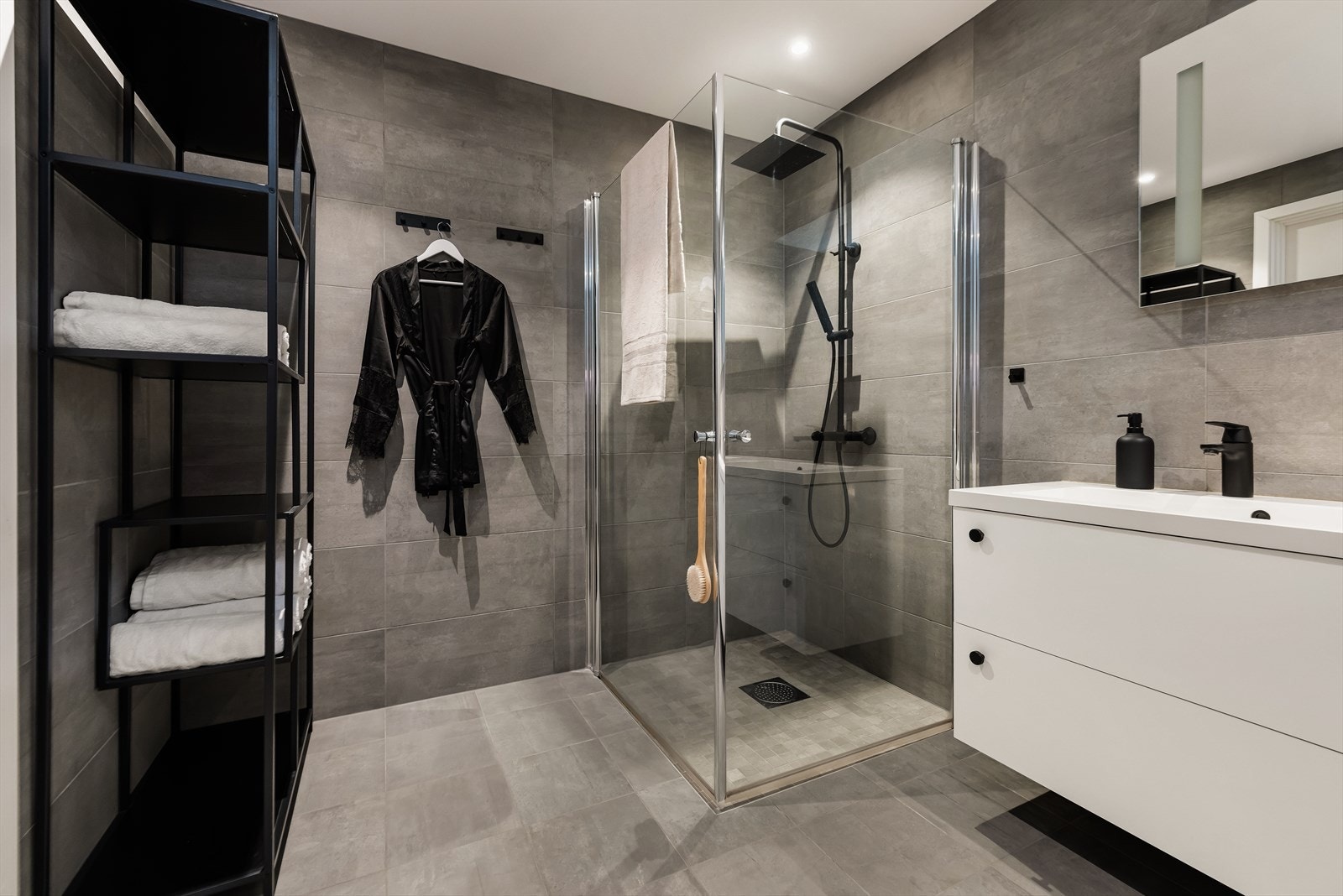 Helfliset bad i svært delikate farger på flis, og sorte detaljer. Varmekabler i gulv. Galleribilde