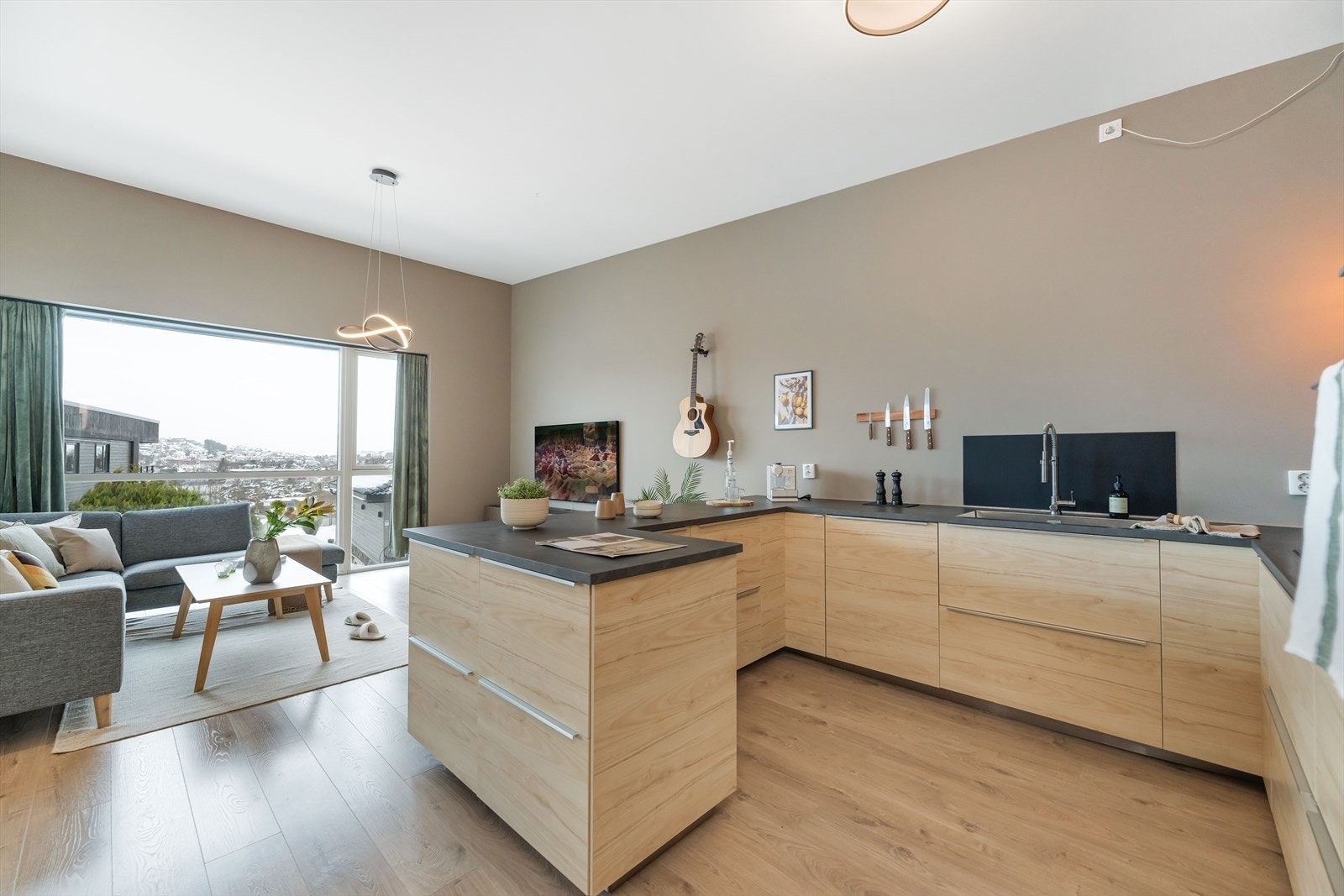 Kjøkken i åpen tilknytning mot spiseplass og stue som er ideelt for både hverdagen og sosiale sammenkomster Galleribilde