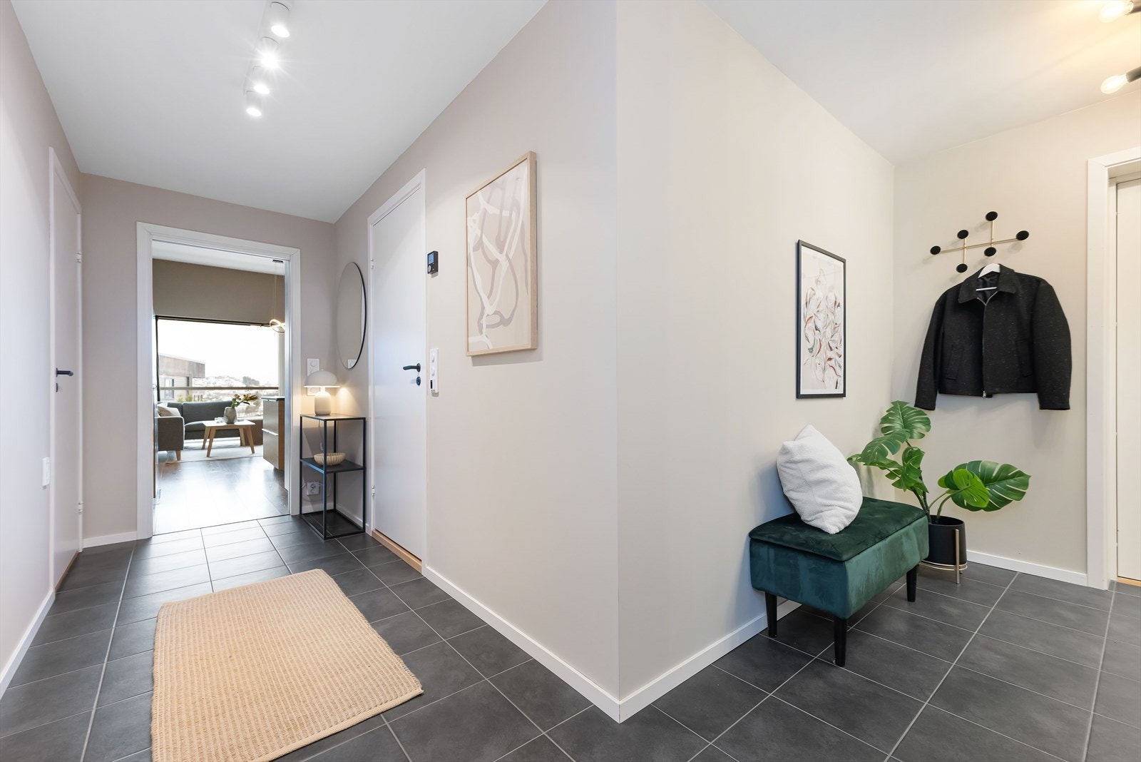 Romslig entre med flislagt gulv og naturlig adkomst videre inn i boligen. Lunt og behagelig førsteinntrykk med gulvvarme hele veien. Galleribilde