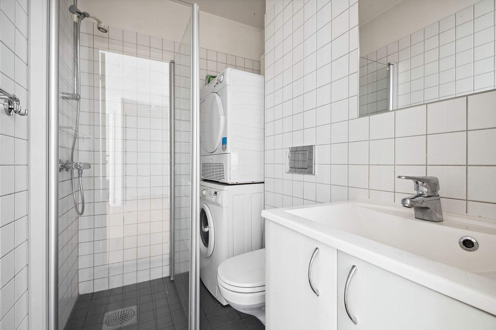 Flislagt baderom med toalett, dusjhjørne og servantskap Galleribilde