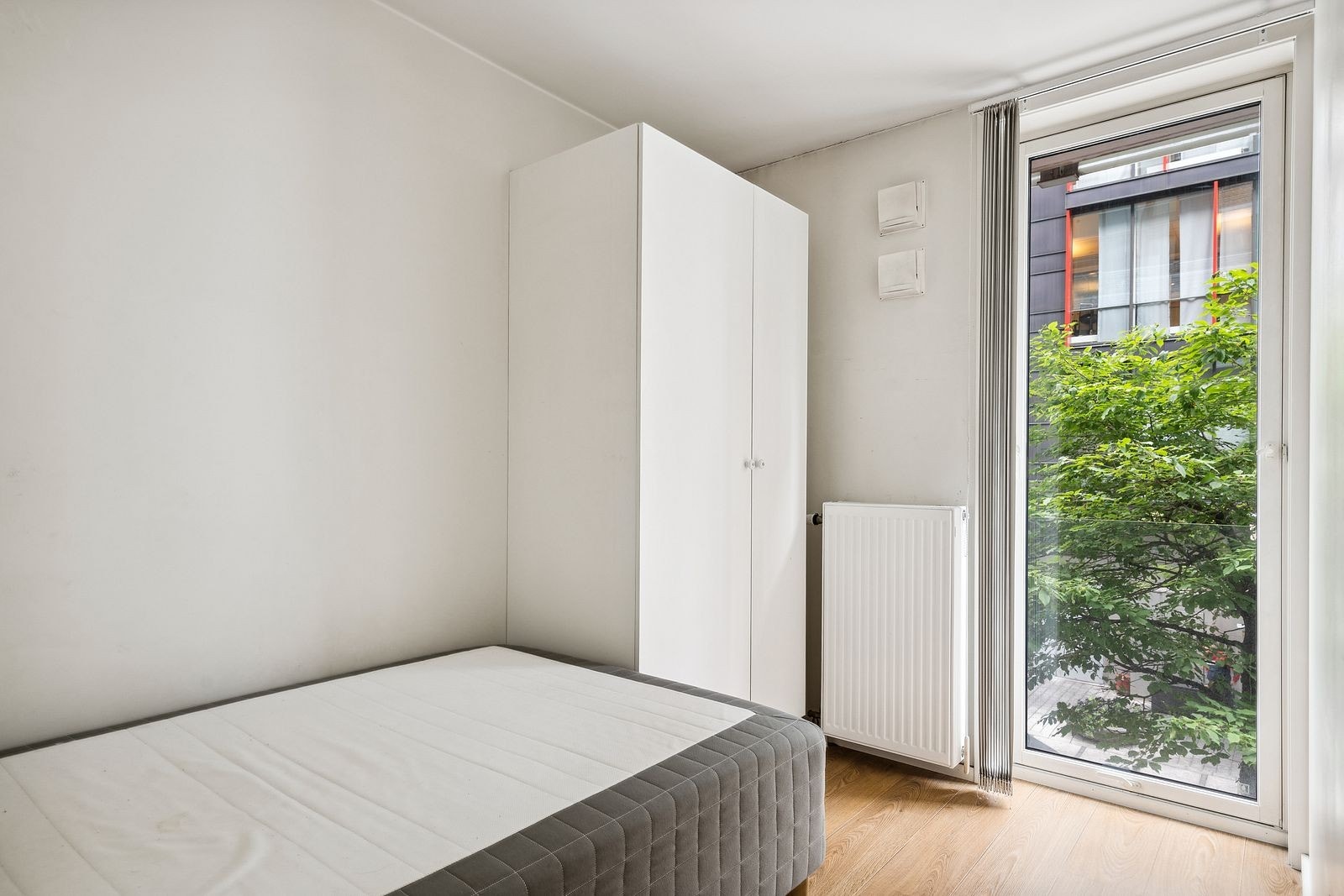 Lyst soverom med god plass til dobbeltseng og skap Galleribilde