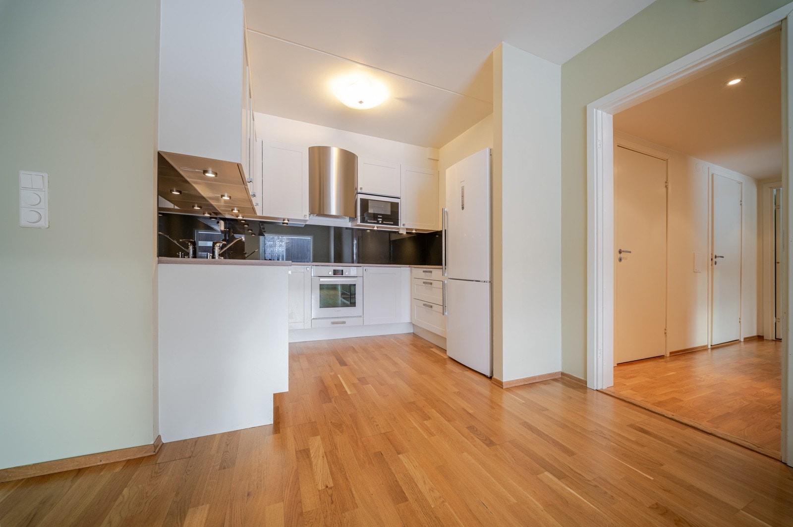 Videre er kjøkkenet utstyrt med integrerte hvitevarer, herav komfyr, platetopp, mikrobølgeovn, oppvaskmaskin og kjøleskap med frysedel Galleribilde