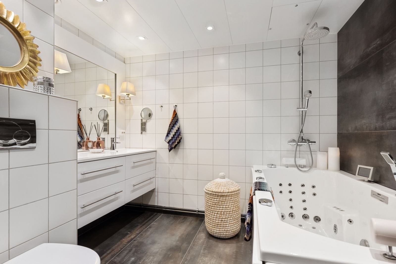 Tilhørende bad, med dobbelvask, vegglamper og stort spesiallaget speil og massasjebad. Det er lagt flis på flis på gulv og en fondvegg, med "betonglook". Oppgradert innredning og ekstra downlights er montert. Galleribilde