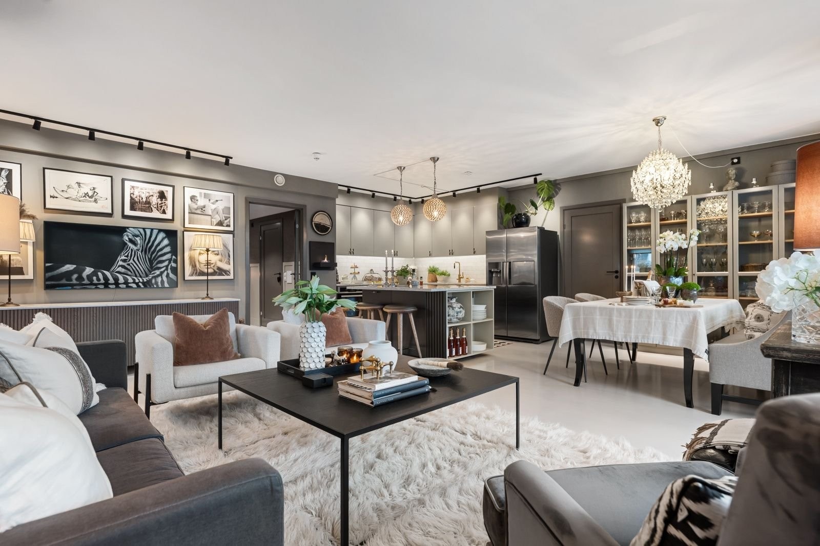 Oversiktsbilde over allrommet med stue, kjøkken og spiseplass. Fargevalget er svært tiltalende, og det går som en rød tråd gjennom hele leiligheten. Galleribilde