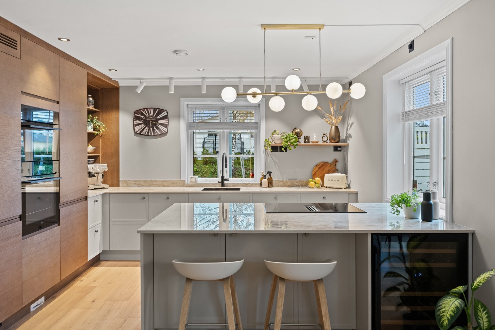 Stilrent og funksjonelt kjøkken fra Strai, nytt i 2023. Innredningen består av integrerte høyskap og hyller i imitert treverk, kombinert med skuffe- og skapfronter i lys utførelse. Galleribilde