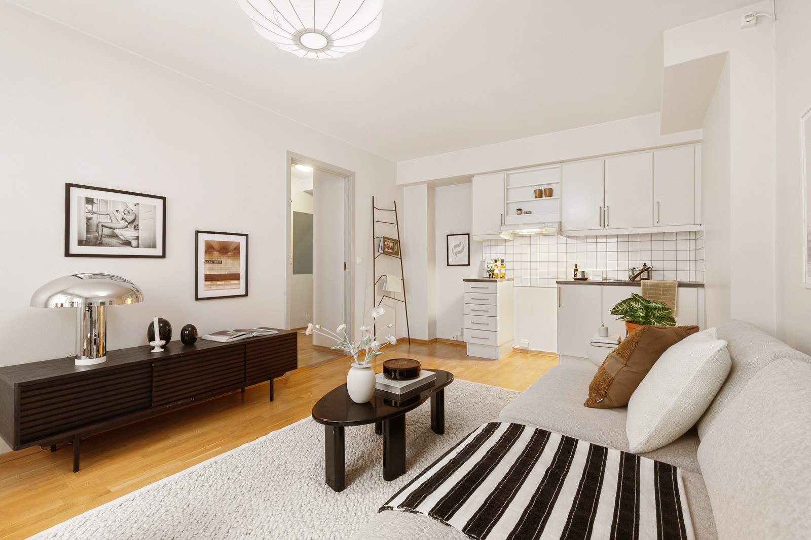 Kjøkkeninnredningen har glatte hvite fronter og grå laminatbenkeplate. Nedfelt vaskekum i børstet stål med ettgreps blandebatteri. Galleribilde