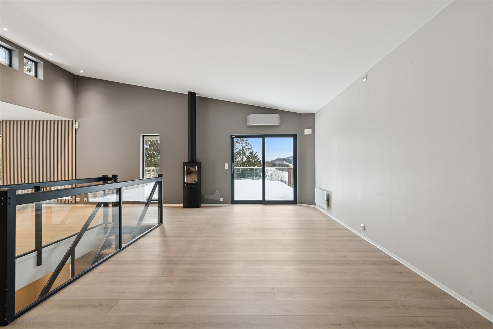 En moderne peisovn gir varme og stemning, supplert av en energieffektiv varmepumpe. Galleribilde