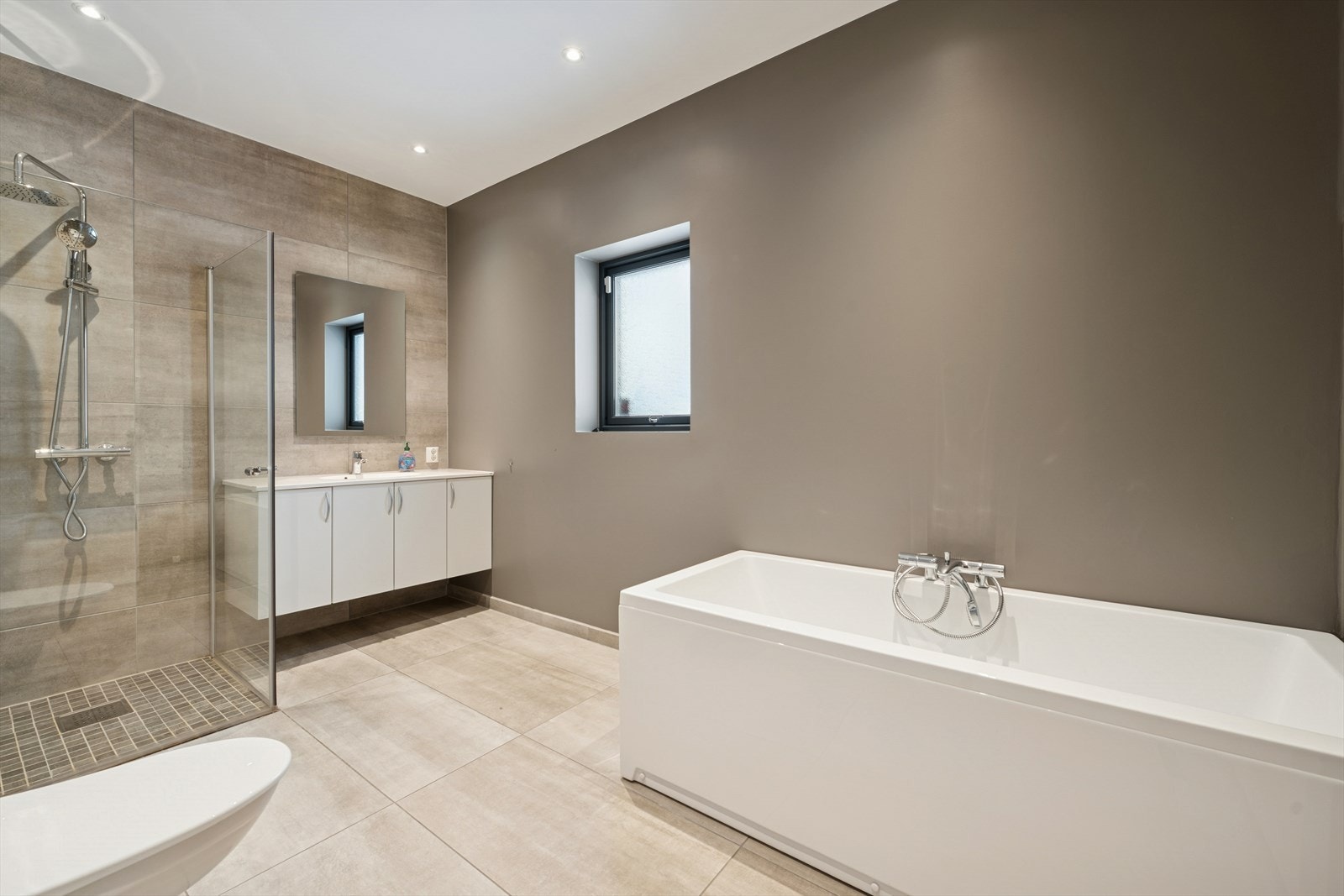 Romslig bad i første etasje med både badekar og dusj, praktisk for en aktiv familie. Galleribilde