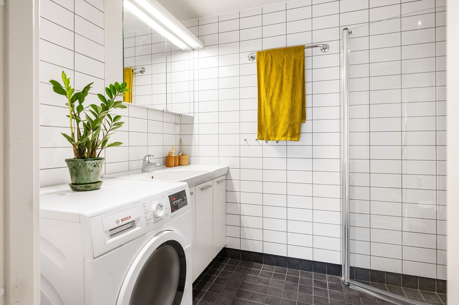 Lyst og pent bad med elektrisk gulvvarme og opplegg for vaskemaskin. Galleribilde