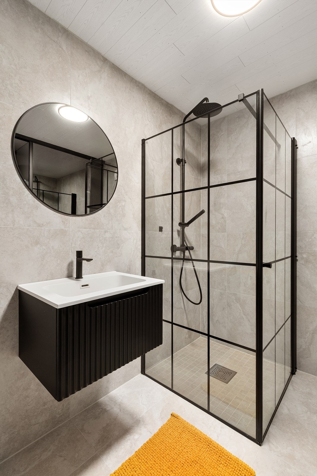 Badet er utstyrt med servant, speil med lys og dusjnisje med glassdører Galleribilde