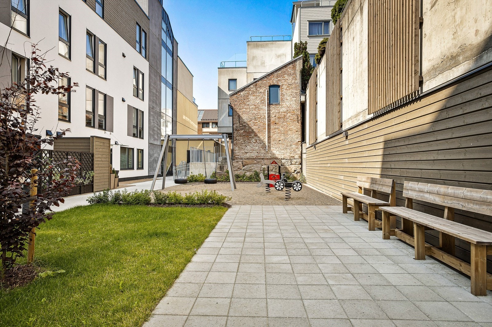 Leiligheten har tilgang til hyggelig bakgård med felles sykkelparkering samt lekeplass med lekeapparater - Sommerbilde fra tidligere annonse. Galleribilde