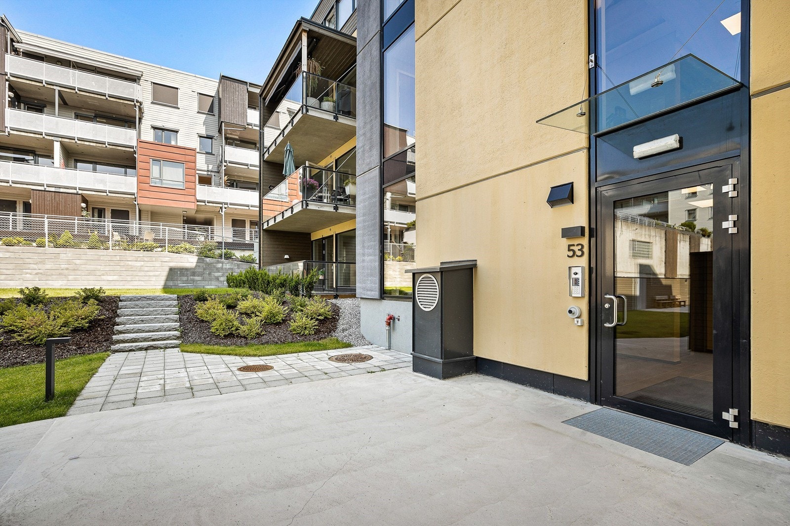 Det er heis- og trappeadkomst i bygningen (inkl. til garasjeanlegget) - Sommerbilde fra tidligere annonse. Galleribilde