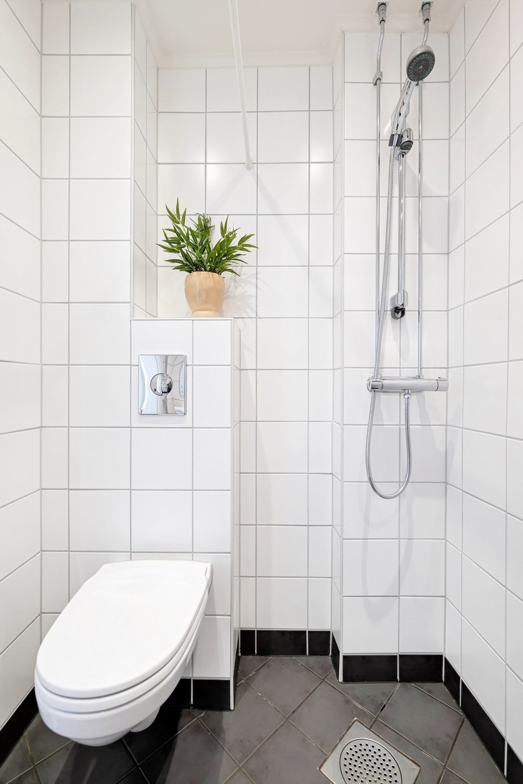 Innredning bestående av servantskap, heldekkende servant, vegghengt WC og dusjhjørne med forheng. Det er opplegg for vaskemaskin. Galleribilde