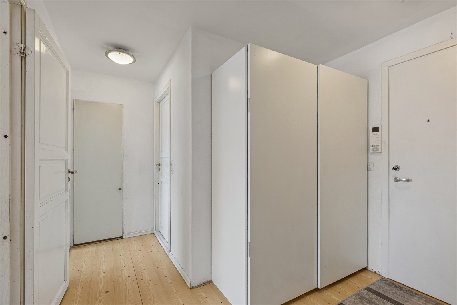 Entréen fremstår innbydende og luftig med lys laminat på gulvet og hvitmalte vegger. Her er det god plass til å henge fra seg ytterklær og sette fra seg sko i medfølgende garderobeskap. Galleribilde