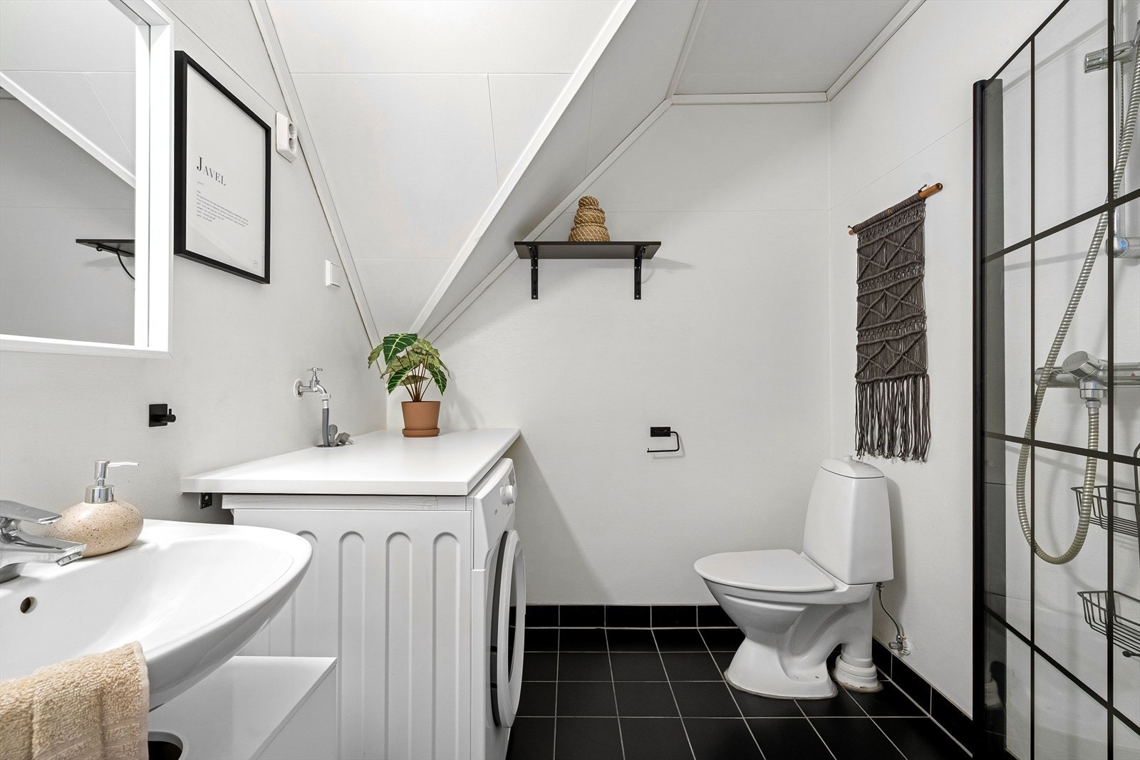 Badet fremstår som tidløst med lyse, nøytrale farger, og er innredet med toalett, servant og flislagt dusjhjørne. Galleribilde