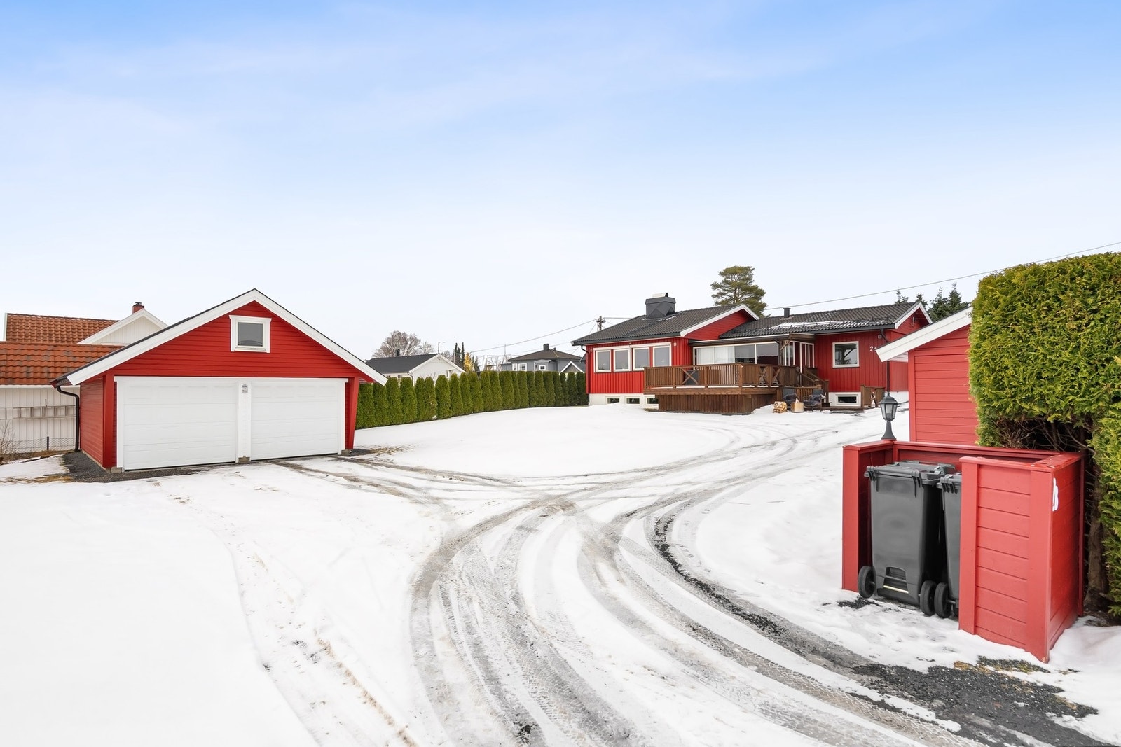 Innbydende gårdsplass med grøntområder og naturlig avgrensning av hekk. Galleribilde