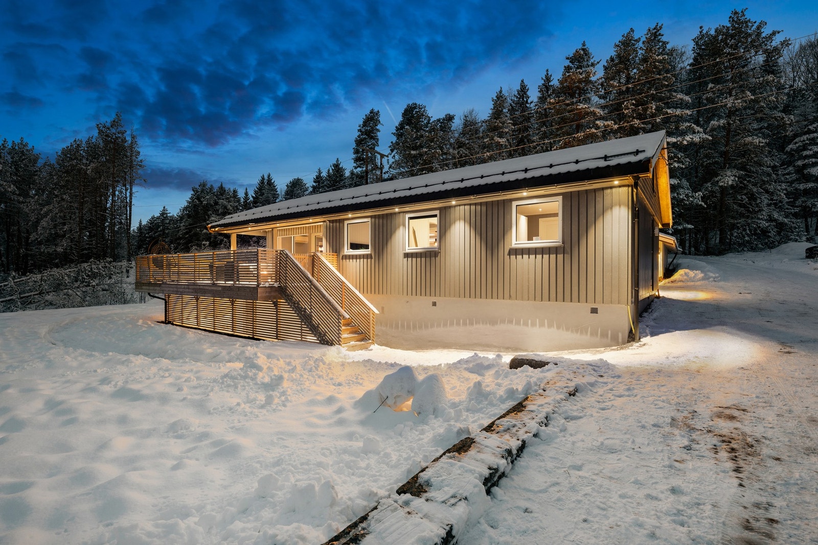 Kveldsstemningen fremhever boligens lune og varme preg. Her får man en attraktiv enebolig med hybel i et etablert og etterspurt boligområde. Galleribilde