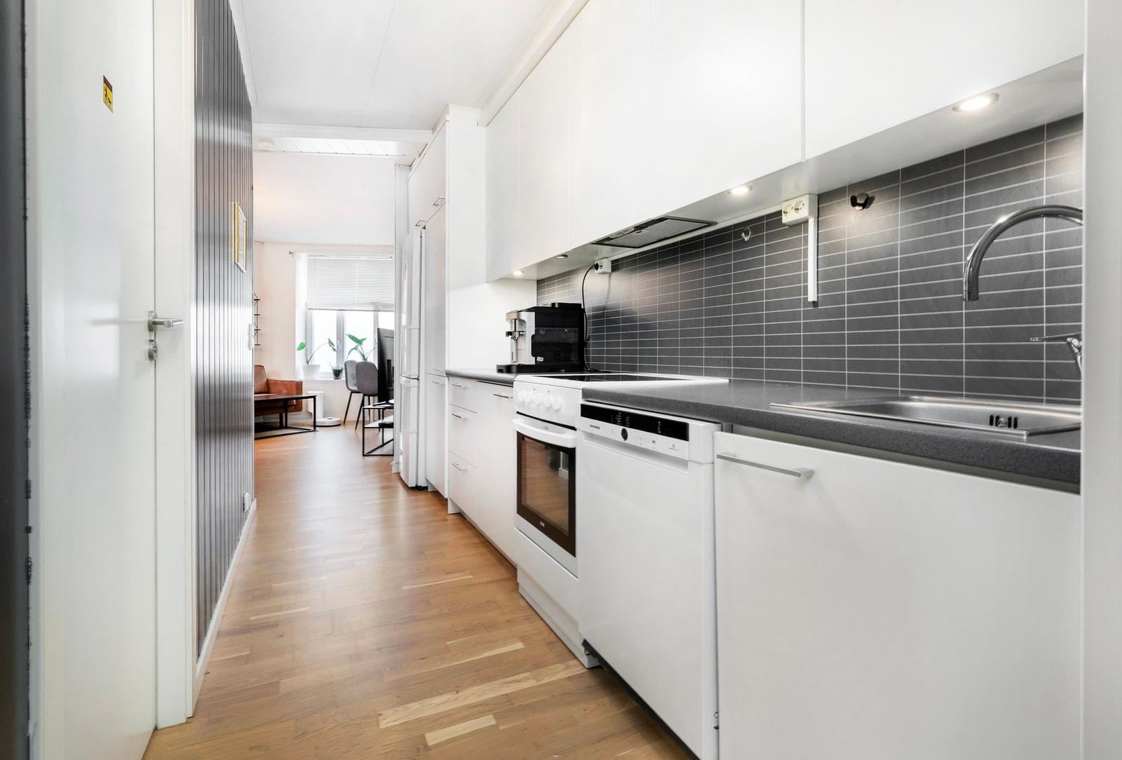 Kjøkkenet har innredning med glatte fronter og benkeplaten av laminat med overlimt vask. Galleribilde