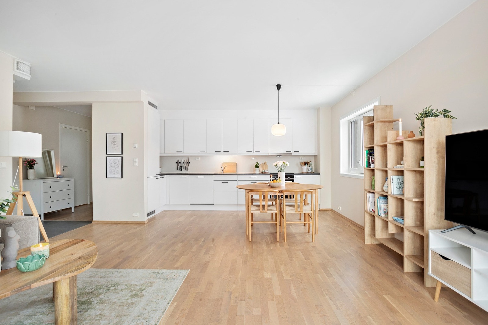 Lyst og romslig kjøkken med åpen løsning mot stue og spiseplass. Galleribilde