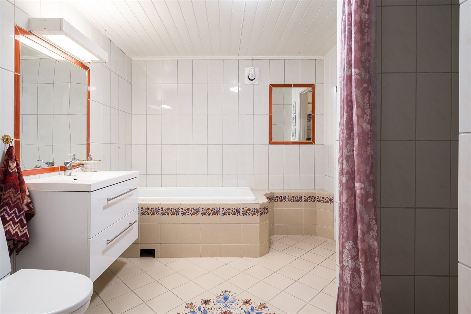 Bad i sokkelleilighet. Består av badekar, dusjhjørne, toalett og hvit baderomsinnredning. Galleribilde