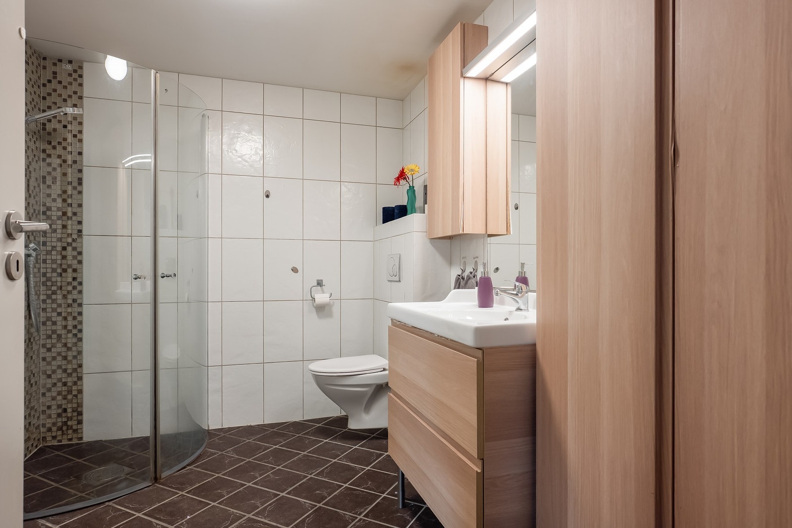 Flislagt bad med varmekabler i gulv. Dusjhjørnet er har innskyvbare dusjvegger, som frigjør plass på badet ved behov. Galleribilde