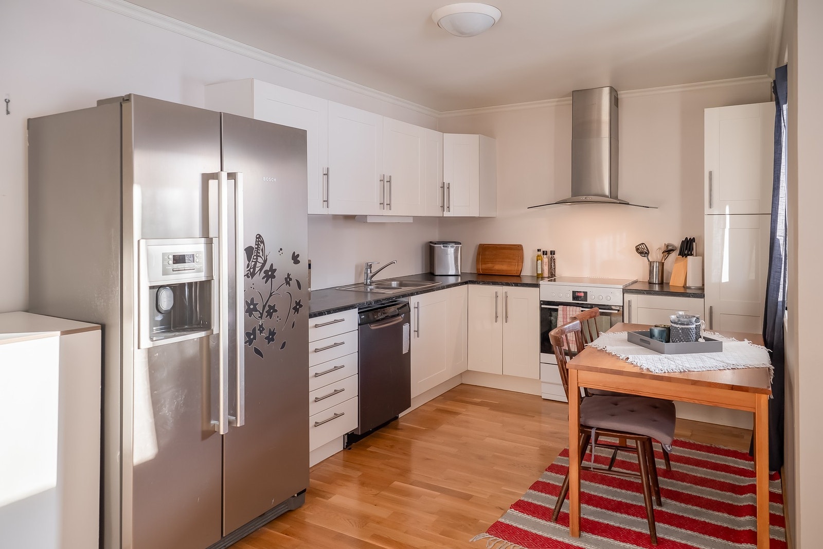 Tidløst kjøkken med folierte skrog, lakkerte fronter og laminert benkeplate. Galleribilde