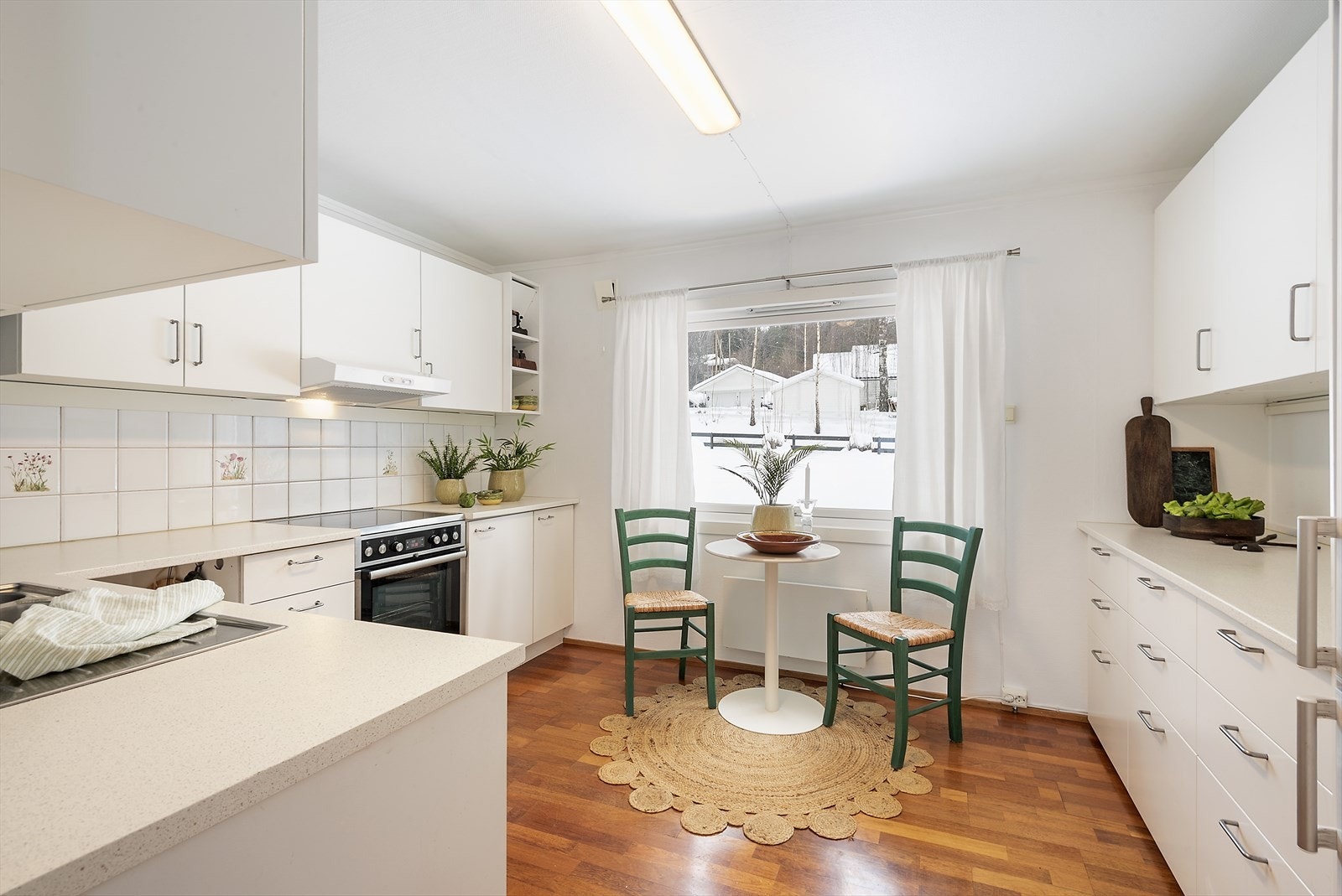 Stort kjøkken med plass til et lite spisebord. Galleribilde