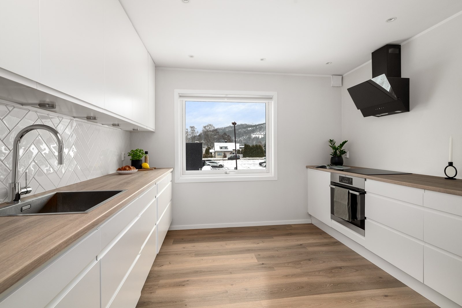 Det moderne kjøkkenet fra 2014 har et håndtaksløst design som fremhever kjøkkenets minimalistiske og strømlinjeformede estetikk. Galleribilde