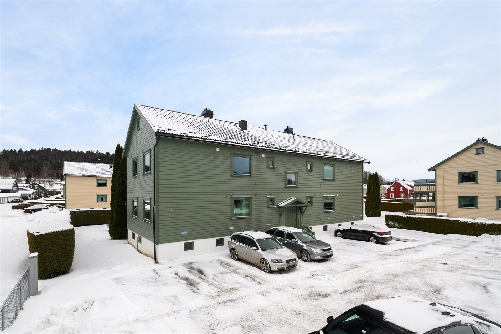 Tomten til borettslaget er opparbeidet med fine grøntområder med plen og prydbusker og asfaltert innkjørsel med parkeringsplasser. Galleribilde