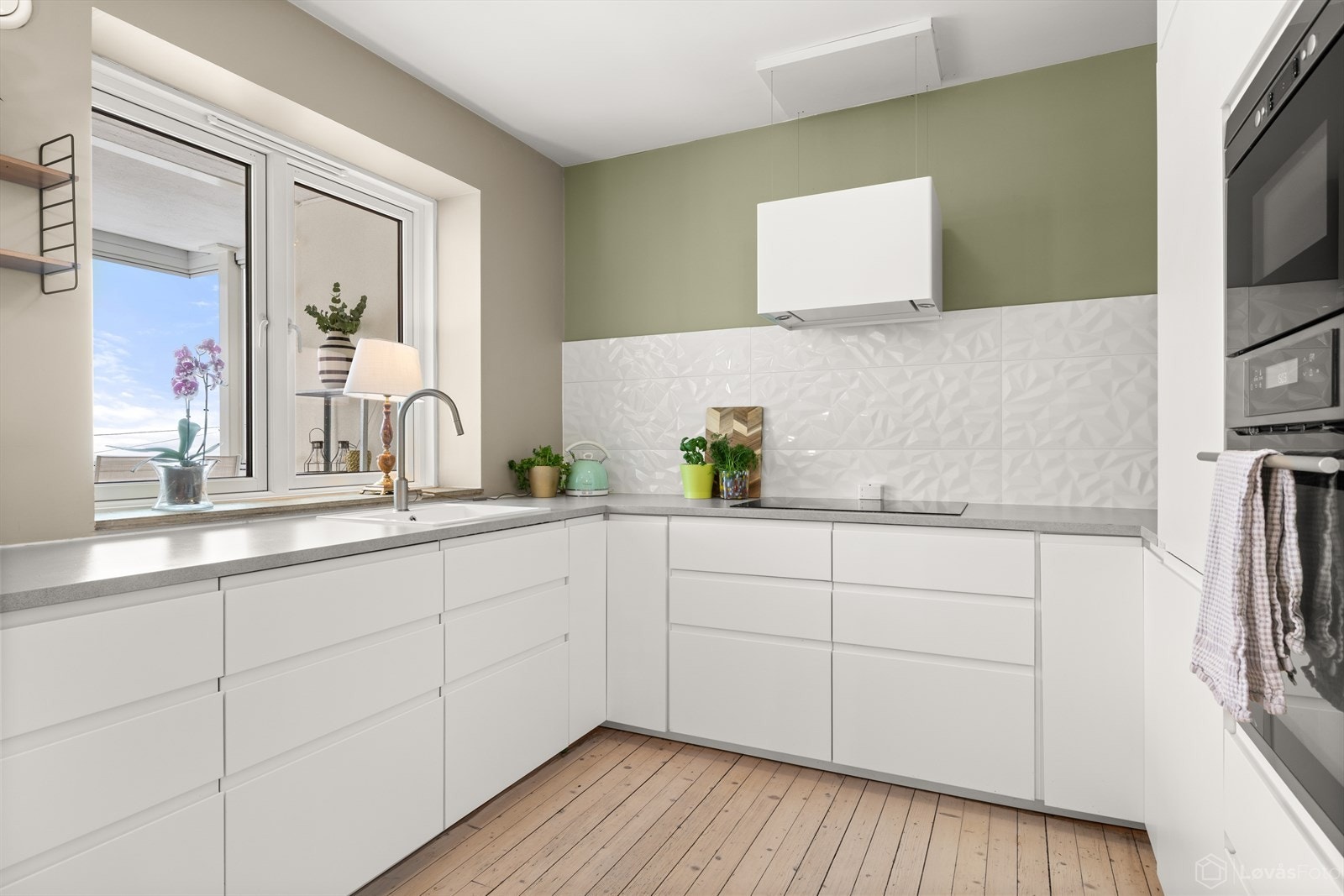 Pent og tidløst kjøkken med glatte fronter og integrerte hvitevarer. Galleribilde