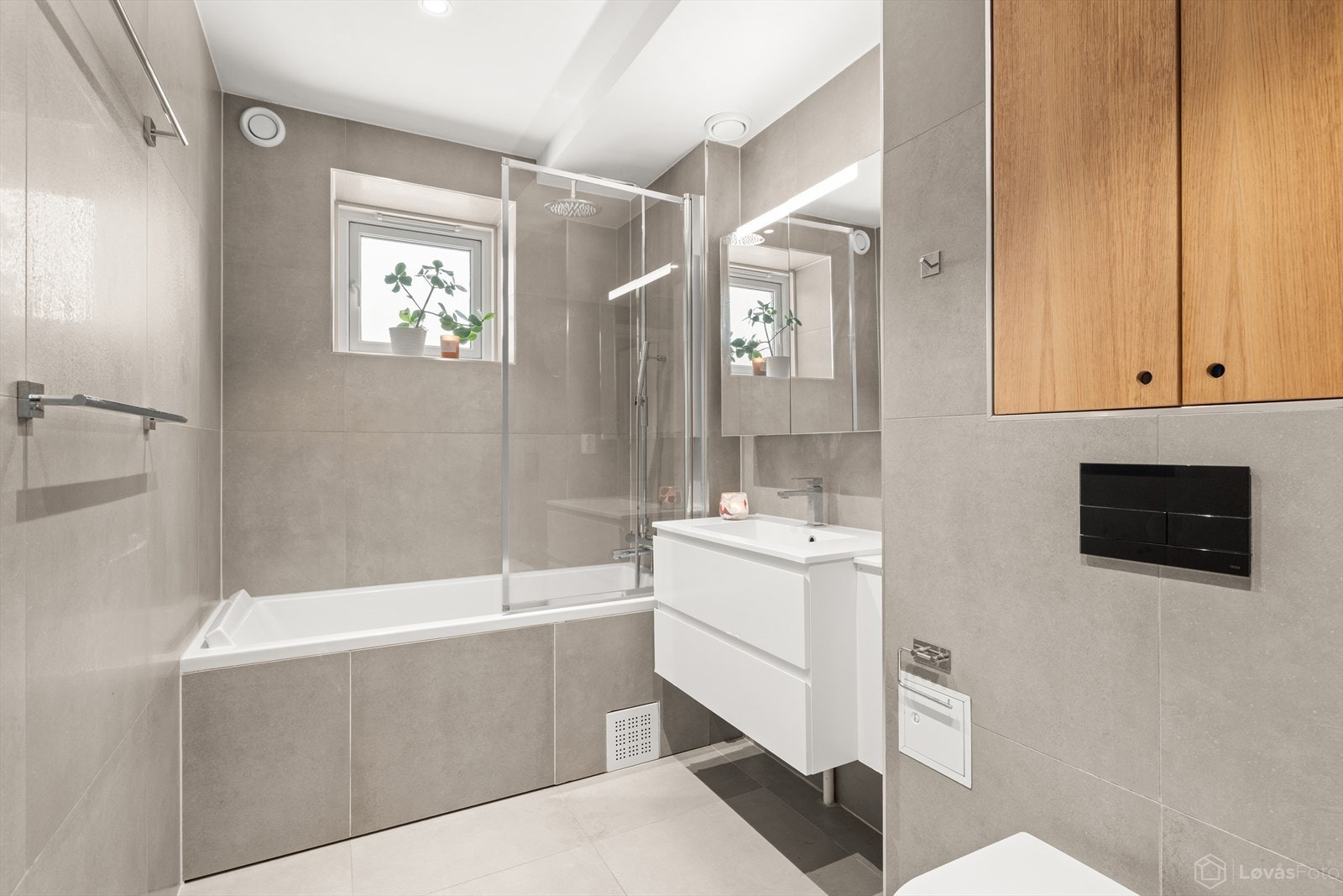 Baderommet | Delikat og stilrent bad, utvidet og oppusset i 2016. Badet er innredet med innebygd badekar med glassdør, servant med innredning og vegghengt toalett. Galleribilde