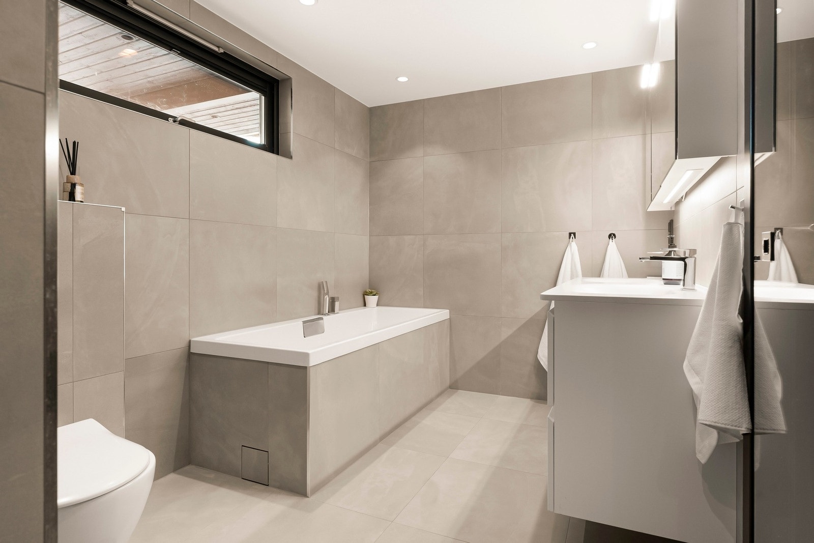 Badet er utstyrt med både dusj og et elegant badekar, som gir en følelse av hverdagsluksus. Galleribilde